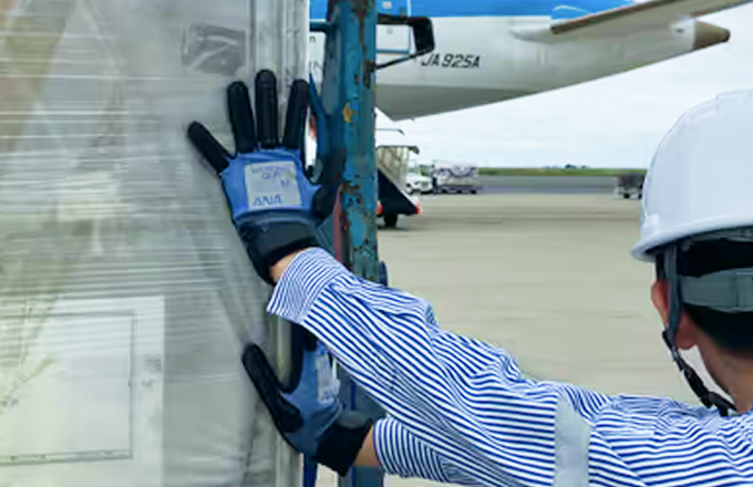 空港で専用グローブを着用して作業する社員